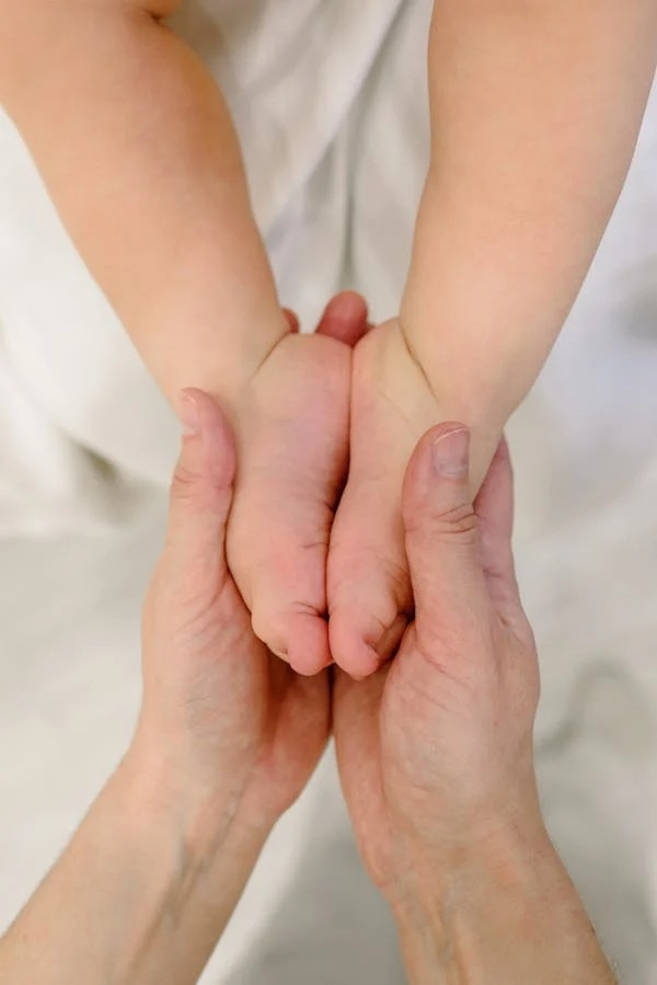 Mãos acolhendo um bebê